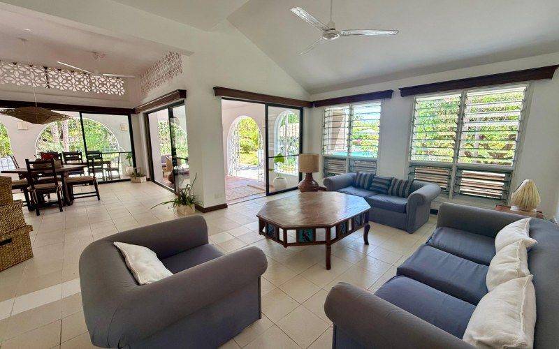 Open-plan living room with sofas and garden views
